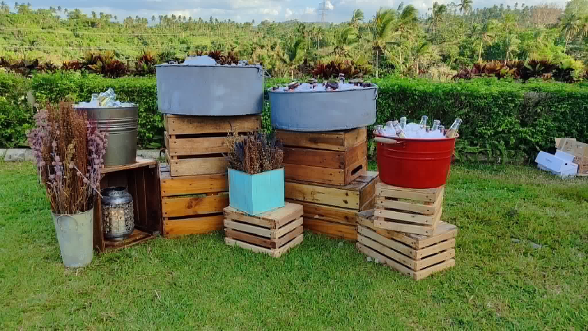 Rustic wooden crates, galvanized tubs, pails, and display blocks arranged outdoors