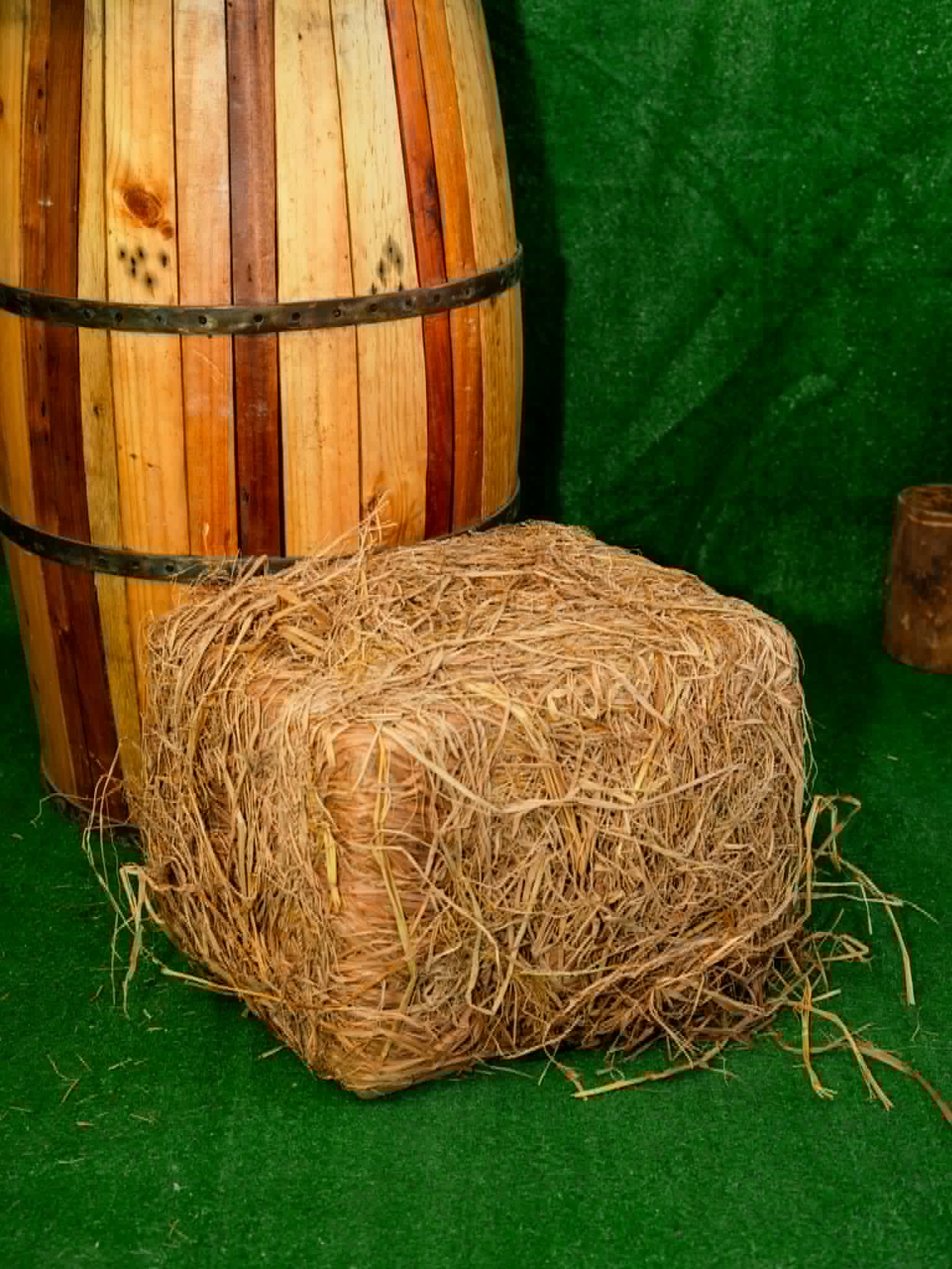 Compact rustic hay bale beside a wooden barrel table