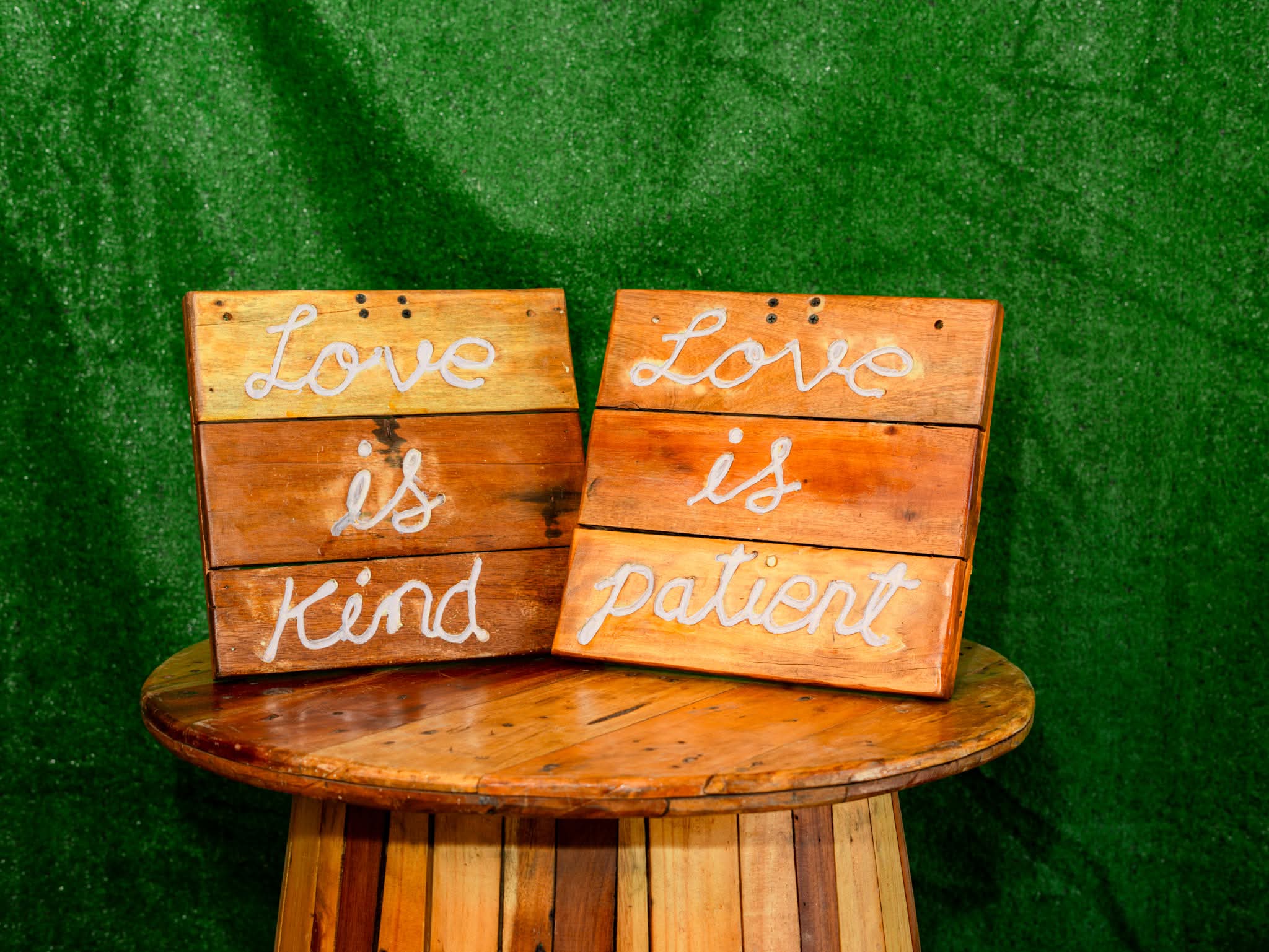 Rustic wooden signs reading Love is kind and Love is patient
