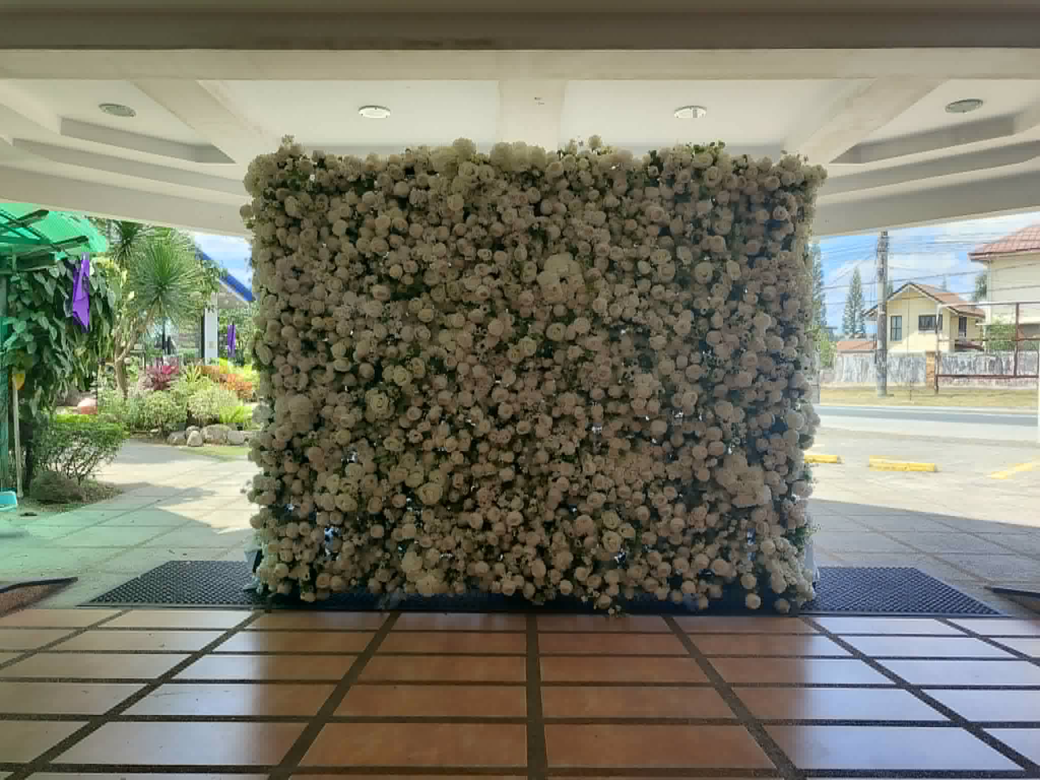 Full blush and white flower wall installed inside a bright event hall