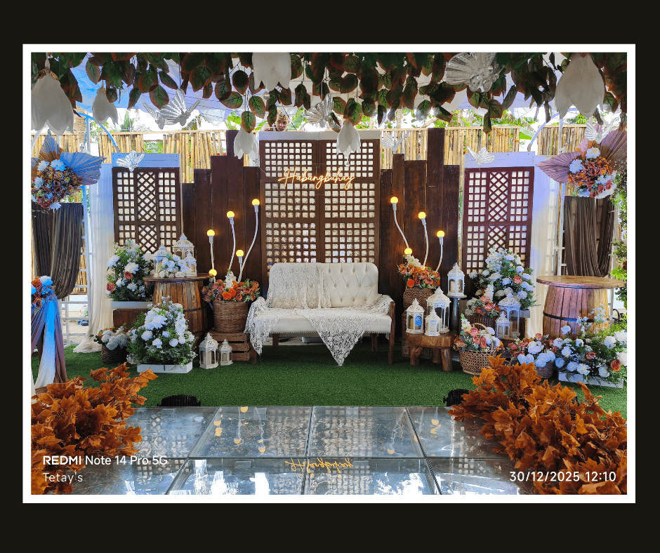 Wide lattice backdrop styling with hanging greenery, colorful florals, and warm lights