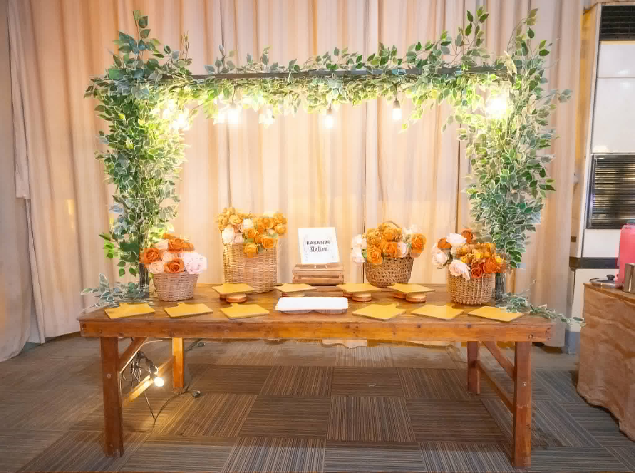 Greenery-wrapped rectangular frame over a rustic dessert and display table