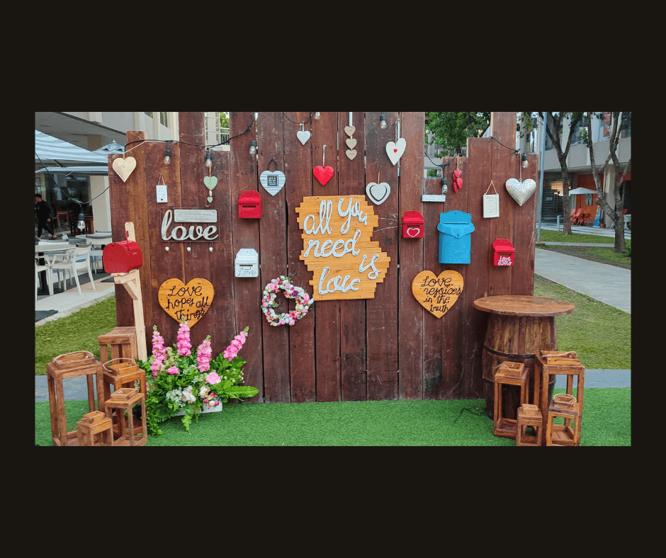 Rustic plank wall displaying colorful cards, hearts, flowers, and love-note signs