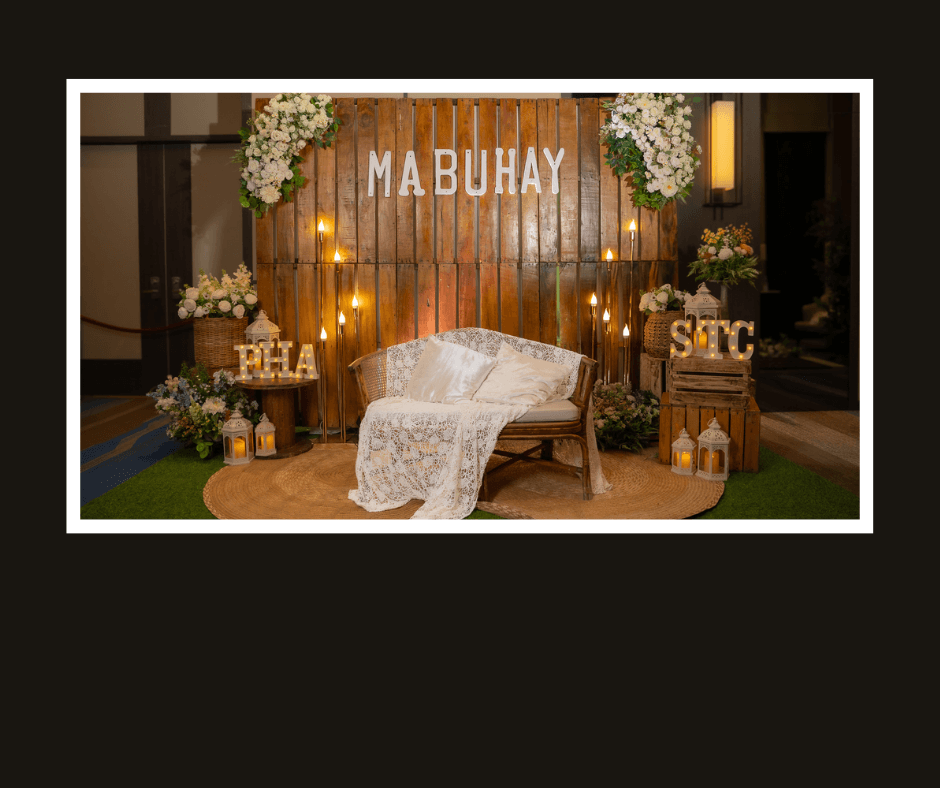 Mabuhay rustic plank lounge wall with warm bulbs, floral corners, barrels, and a white loveseat