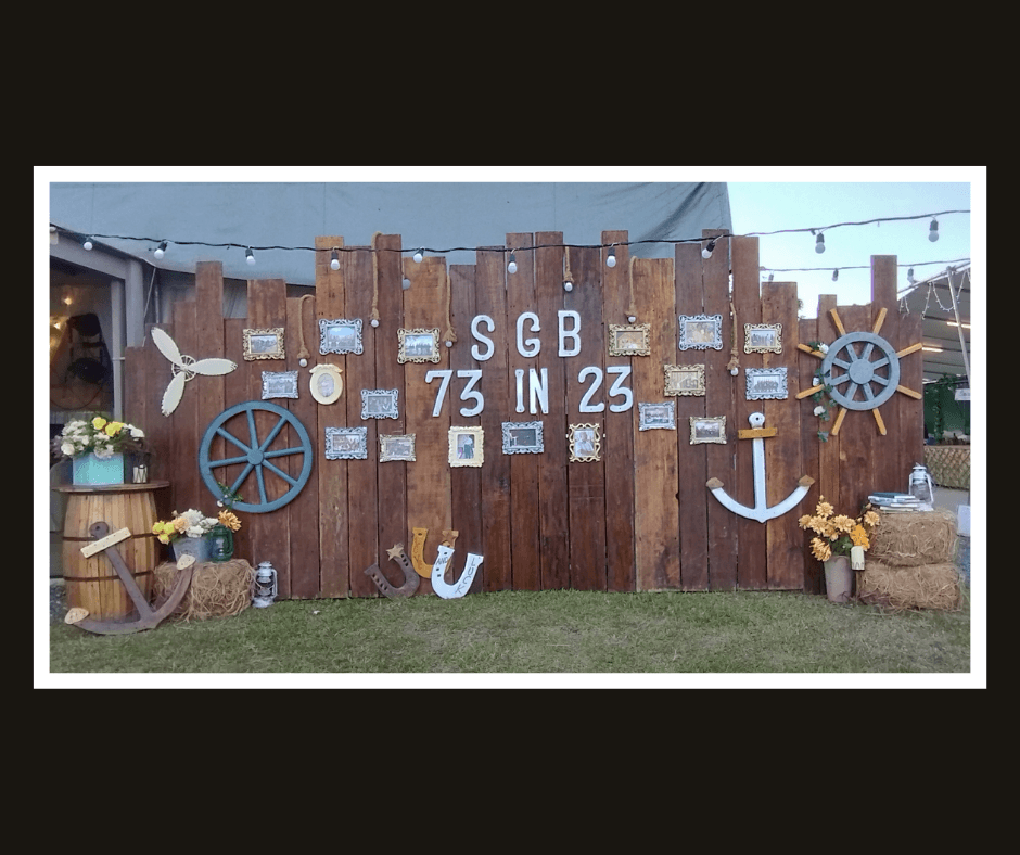 Wide rustic plank photo wall decorated with anchors, ship wheels, rope, and nautical props