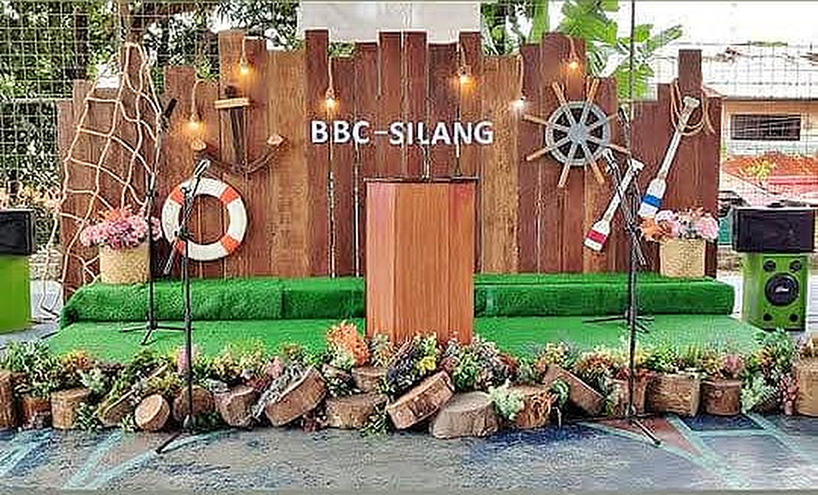 Nautical corporate stage wall with rope, life ring, anchors, and a central lectern