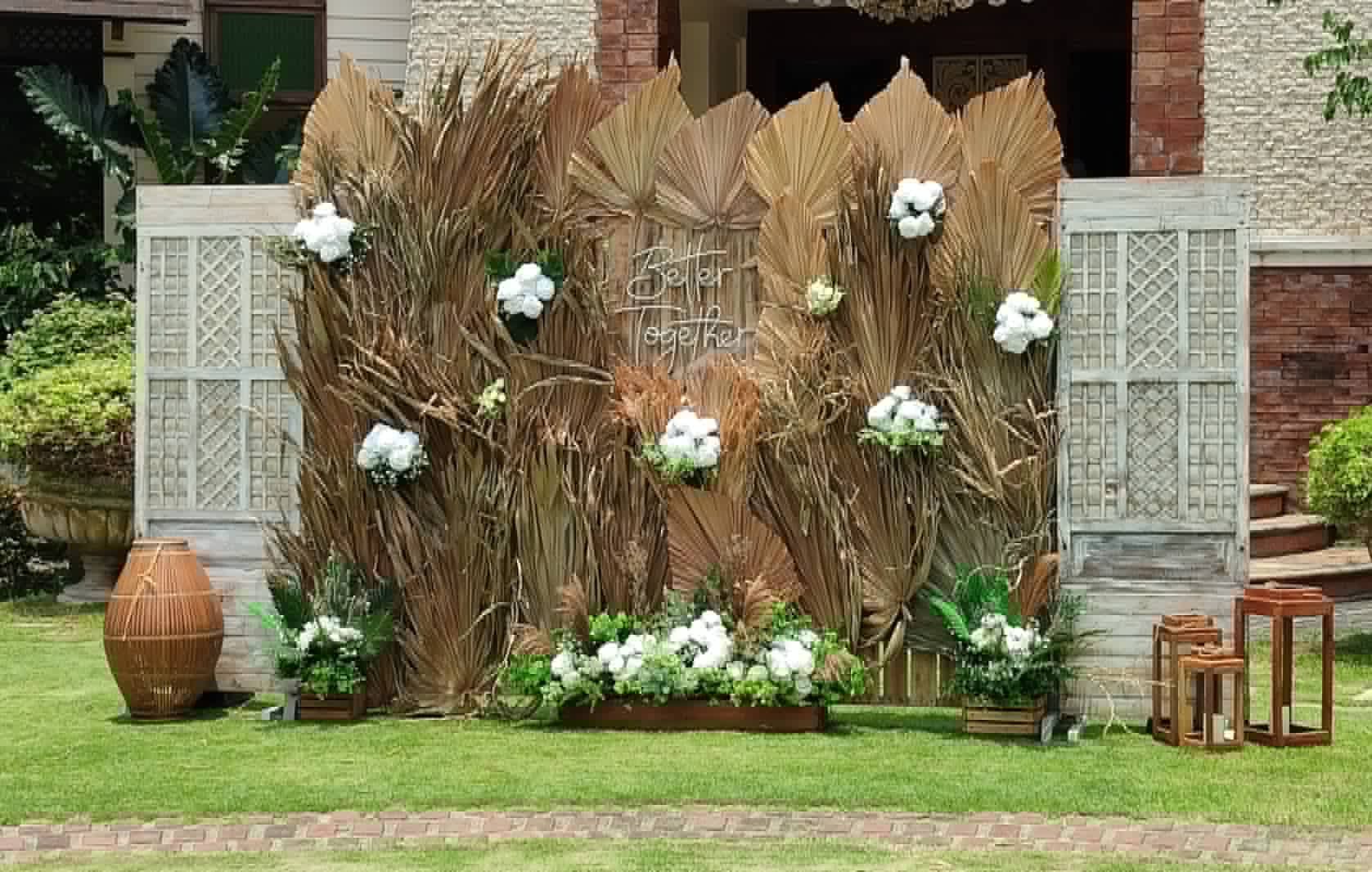 Large pampas grass backdrop with white flowers and white lattice side panels
