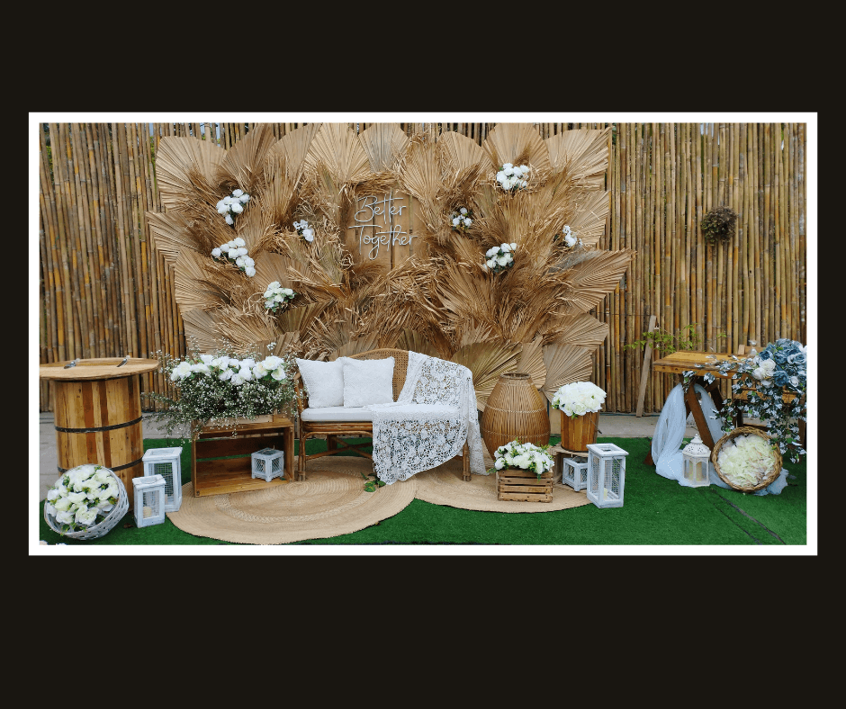 Layered pampas and dried palm leaf wall behind a white loveseat