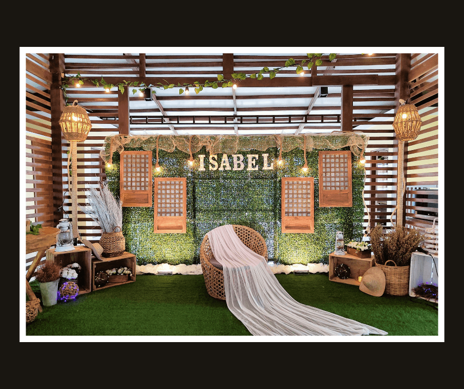 Tall rustic slat wall with greenery panels, woven lanterns, and tropical styling