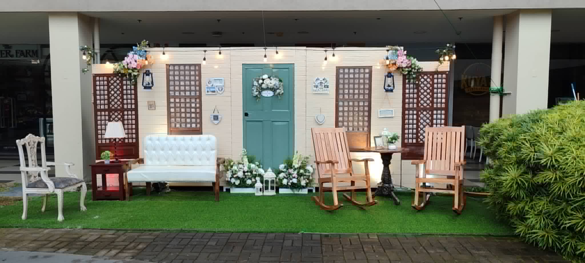 Vintage panel backdrop with mismatched lounge chairs, flowers, and decorative doors