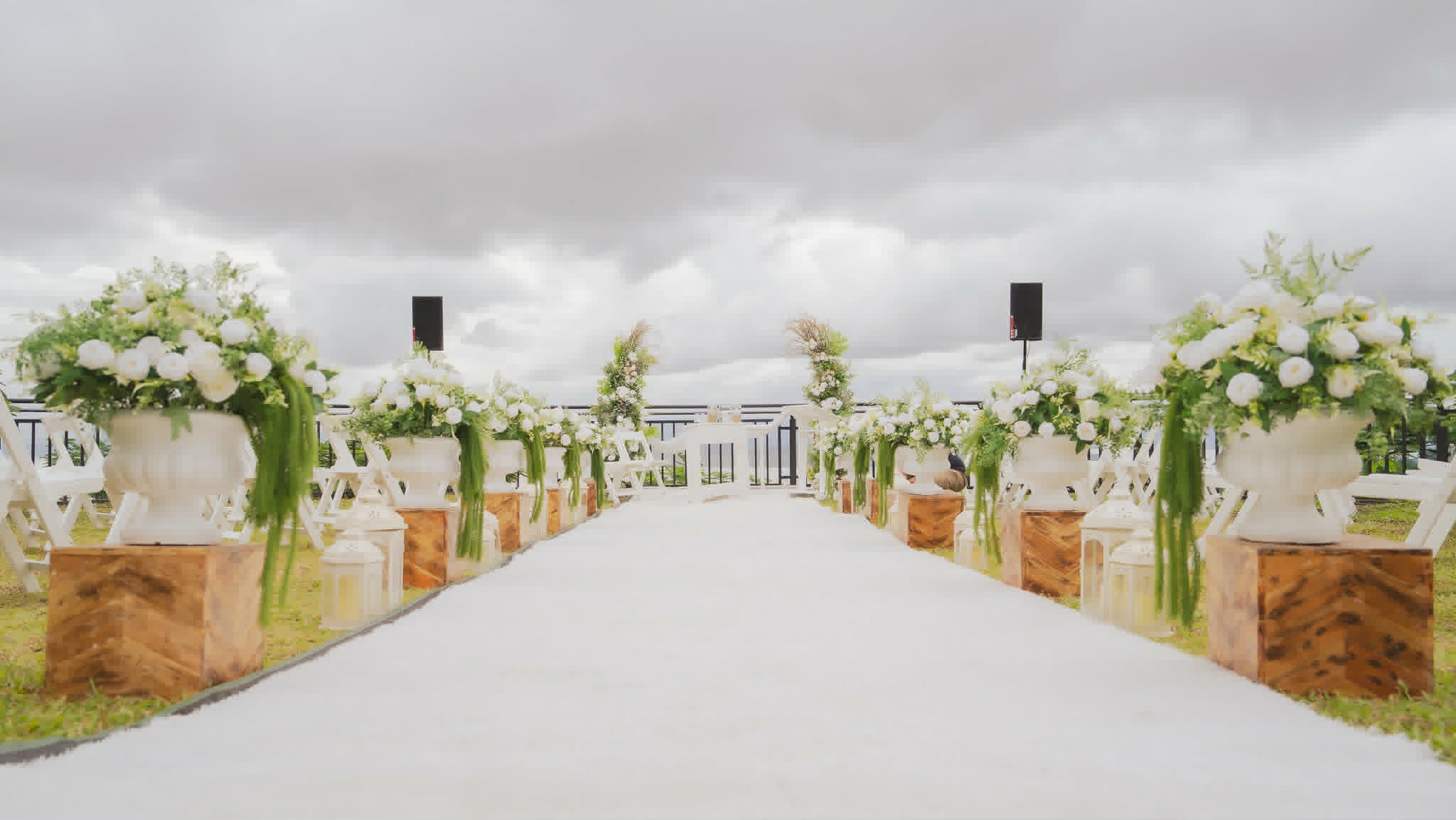 White wedding chairs and aisle decorated with wooden crates and white flowers
