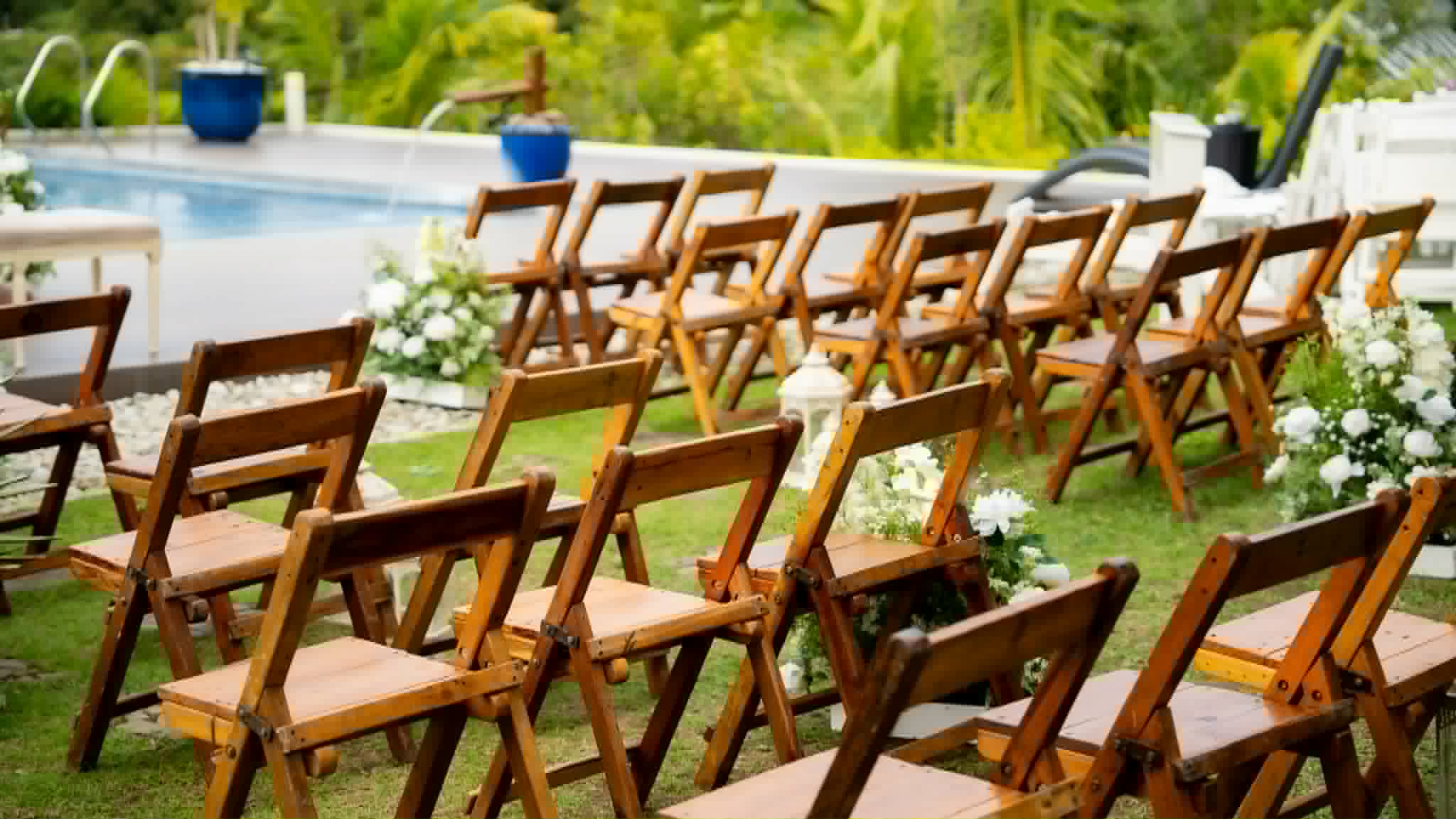 Rows of warm wooden folding chairs arranged beside a swimming pool