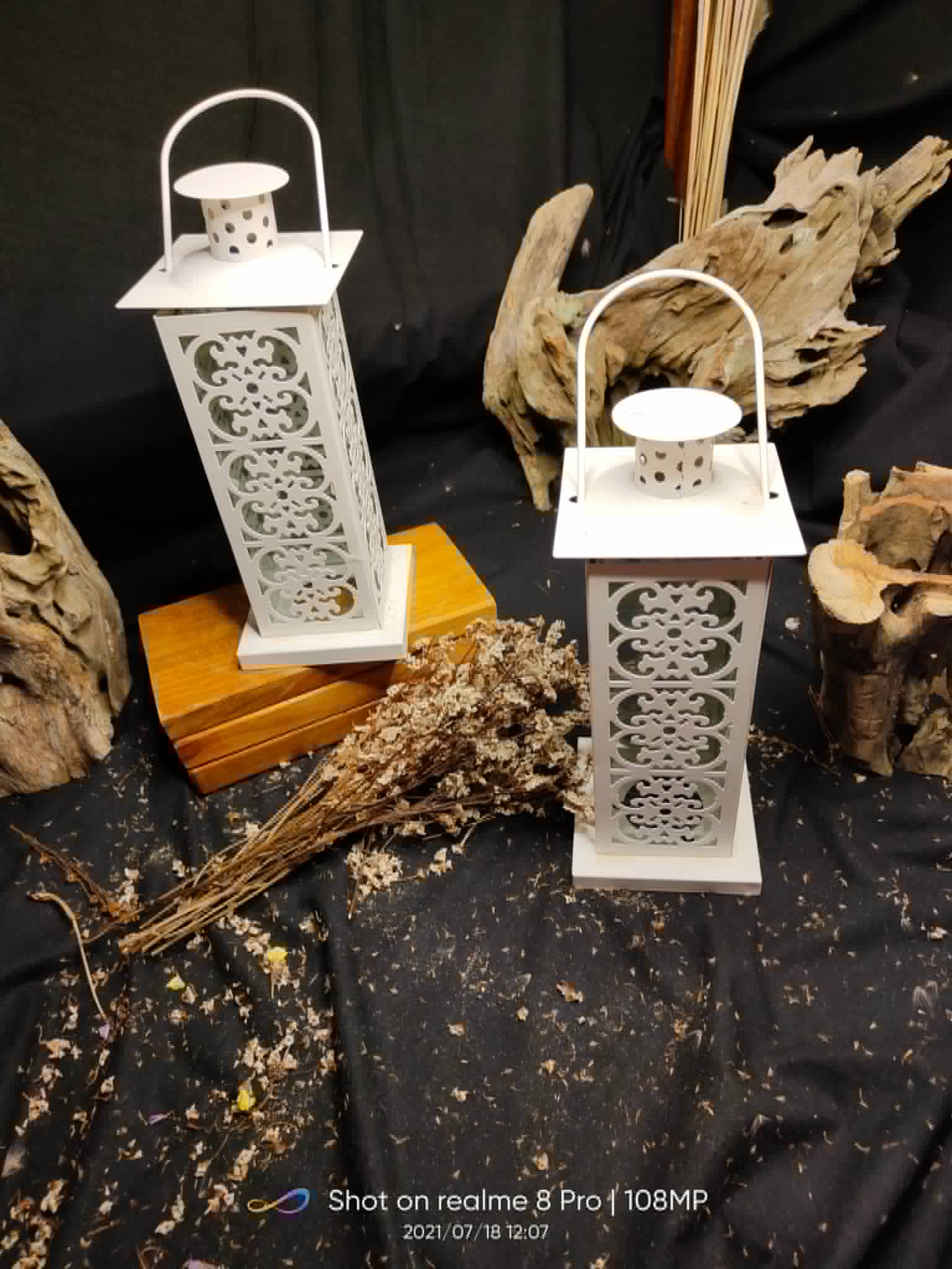 Three white decorative filigree lanterns in mixed shapes