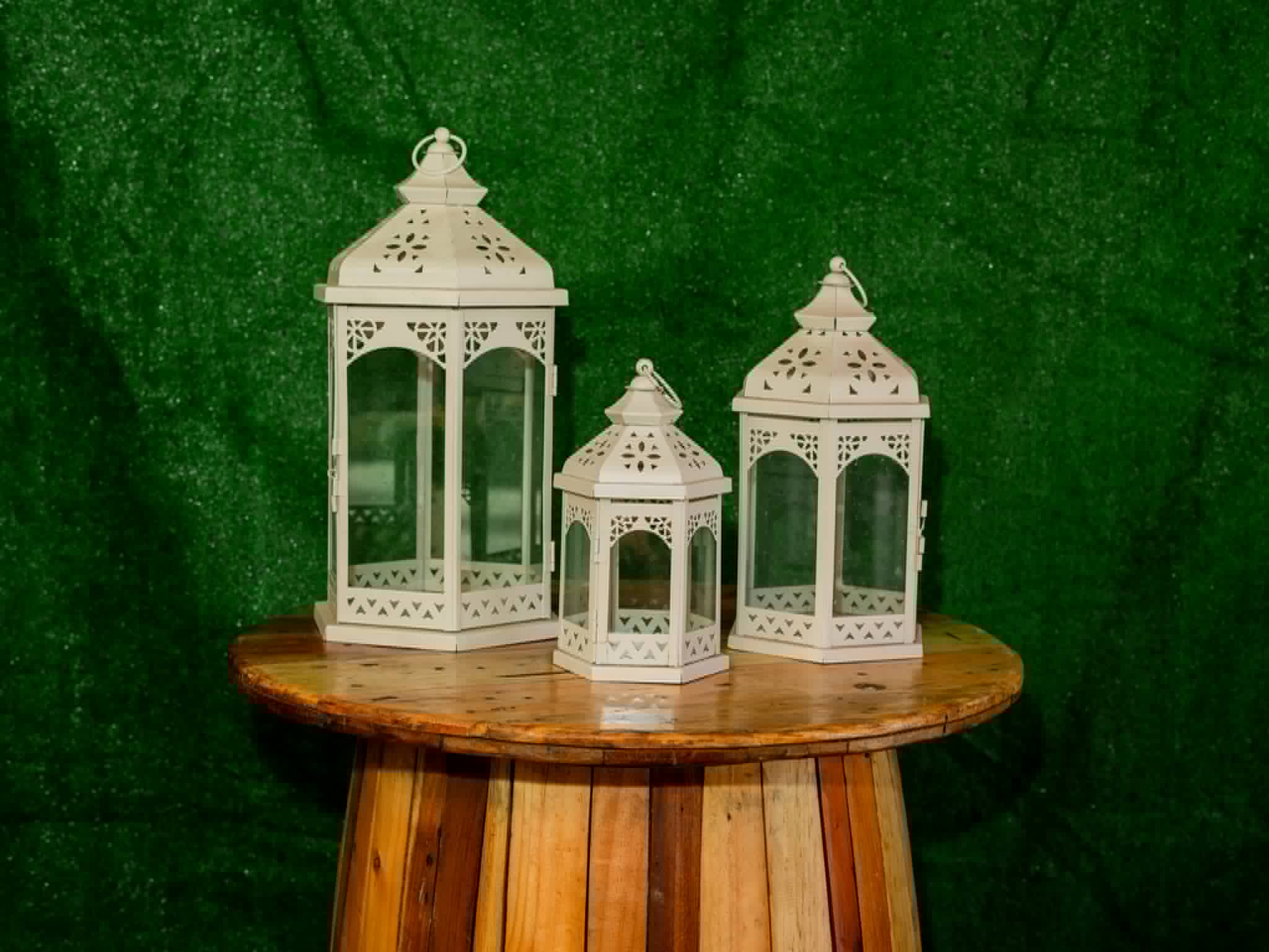 Set of three ornate white metal lanterns in graduated sizes
