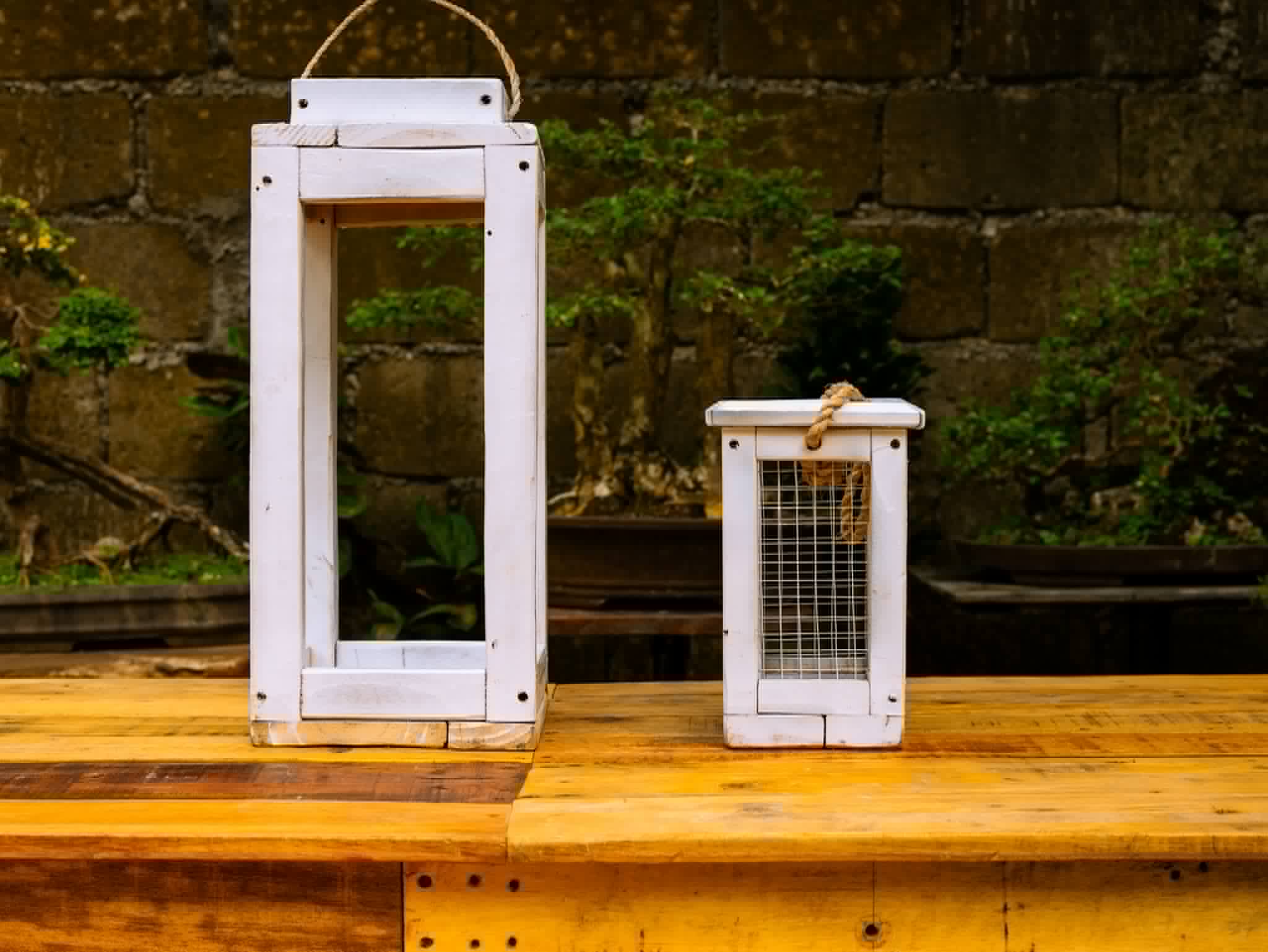Tall and small white wooden lanterns with rope handles