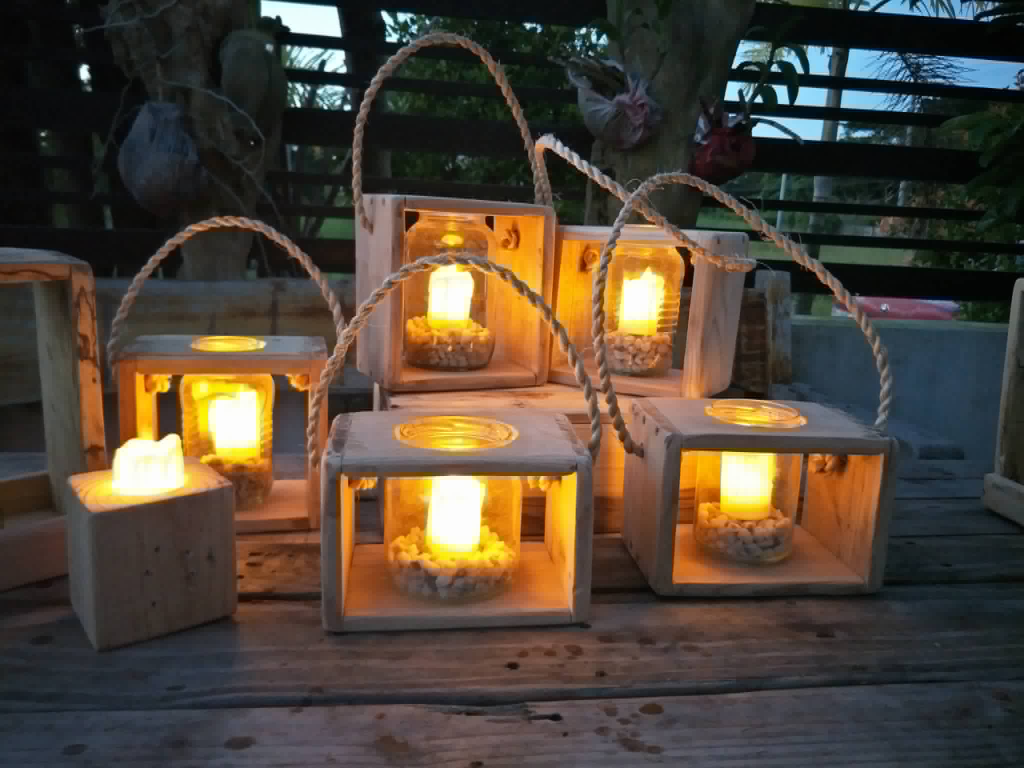 Collection of square wooden cube lanterns glowing with candles