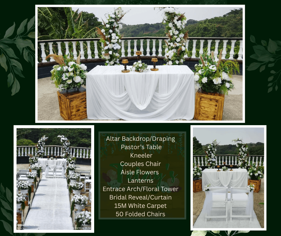 Outdoor white ceremony table in front of white railings and flowers
