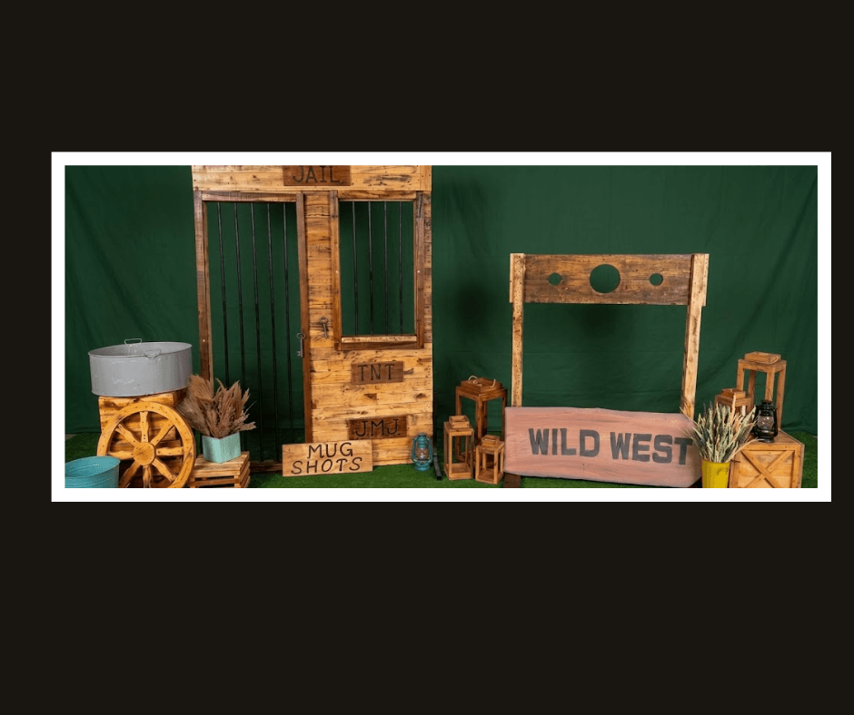Two freestanding rustic western photo-stock props with face openings and themed accessories