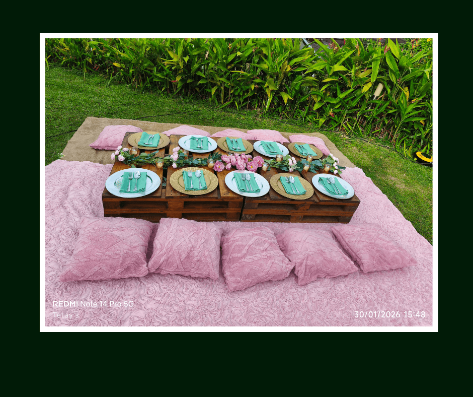 Low pallet picnic table with pink floor cushions and colorful place settings