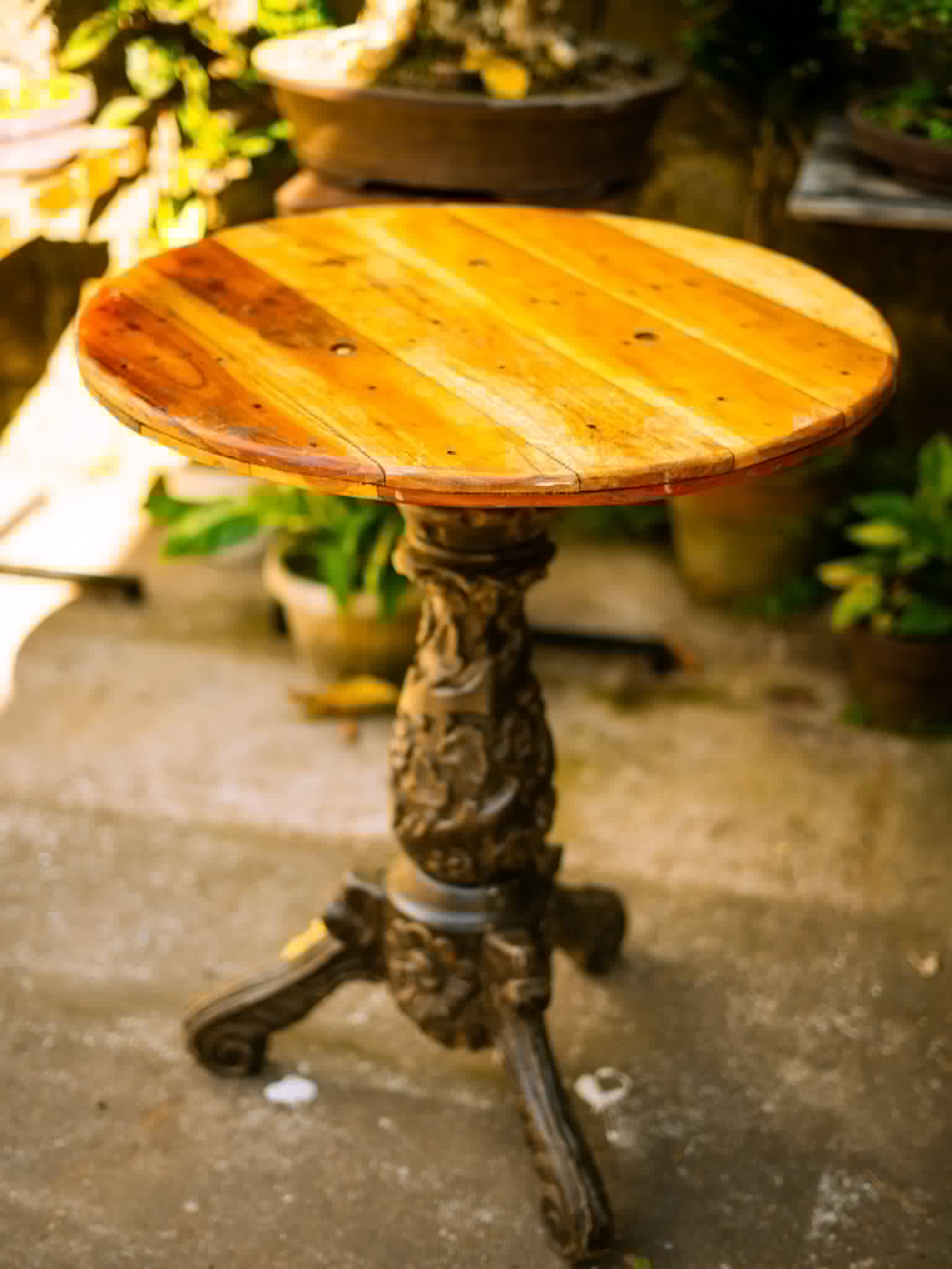 Round wooden accent table with ornate cast-iron base