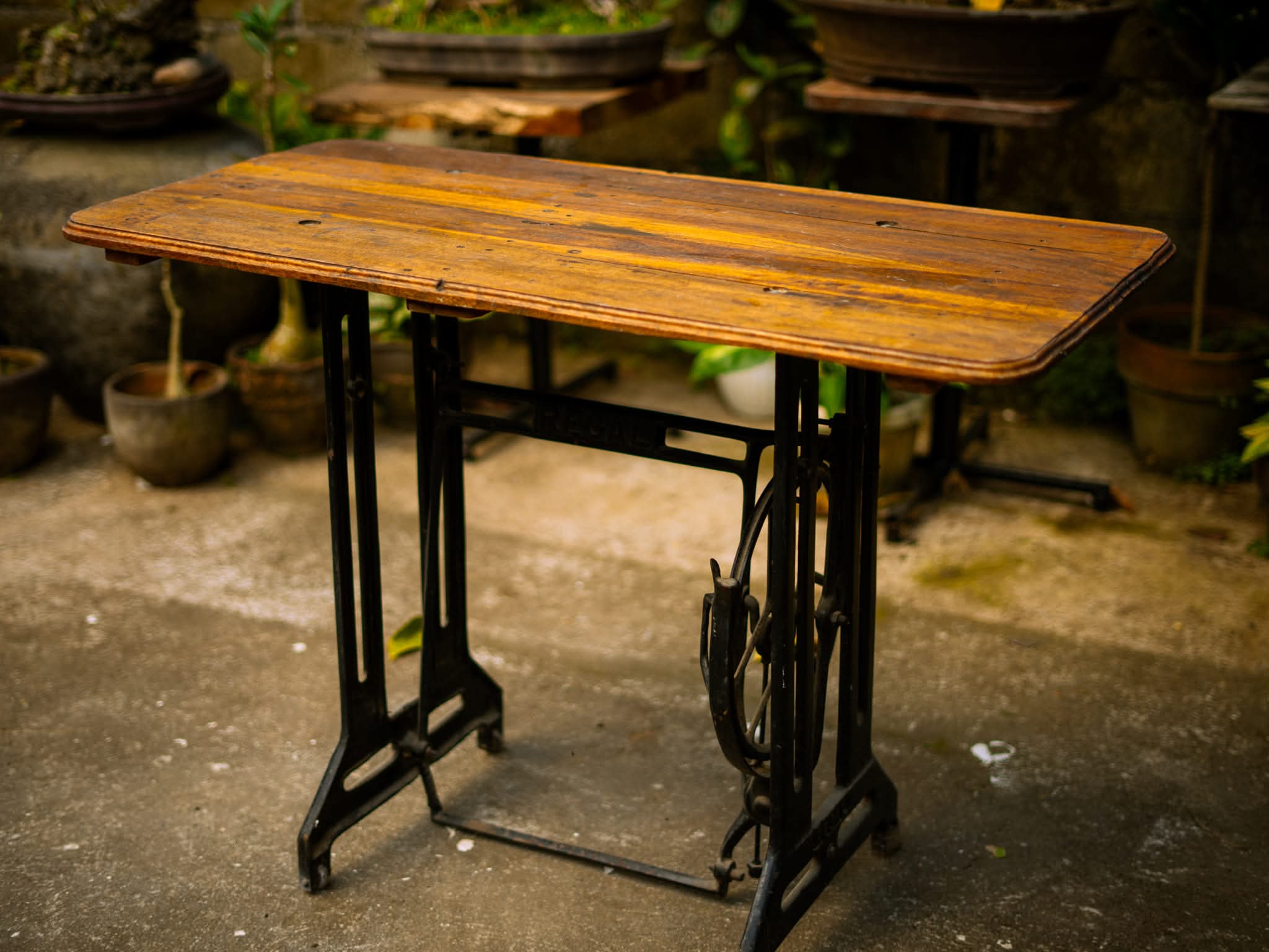 Vintage wood table with a cast-iron sewing-machine base